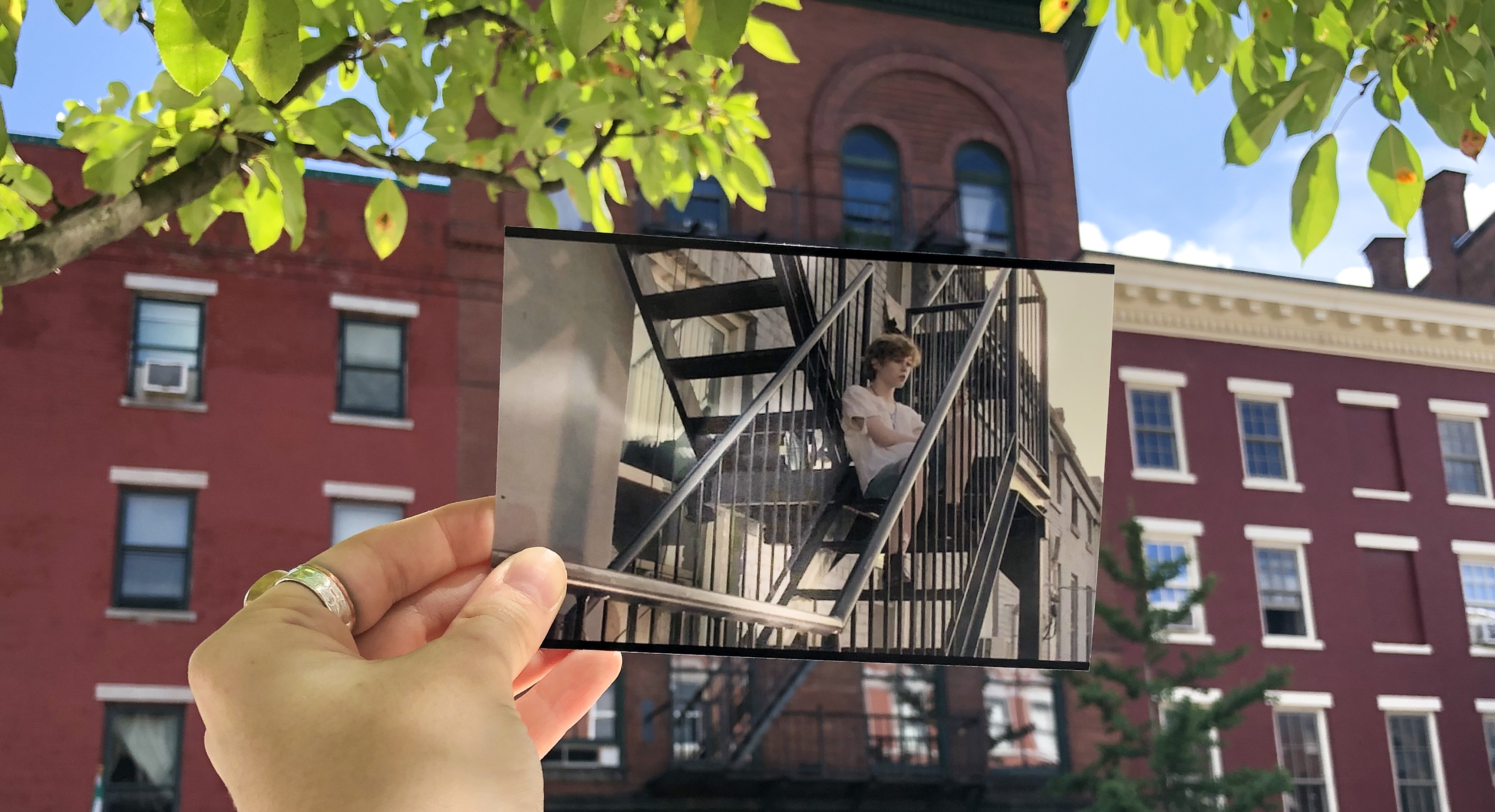 A photo taken from IT 1 of Beverly Marsh sittkng Outside Her Apartment at the actual location that inspired the image.