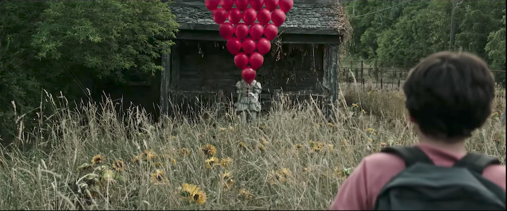 Pennywise holding a large arrangement of red balloons