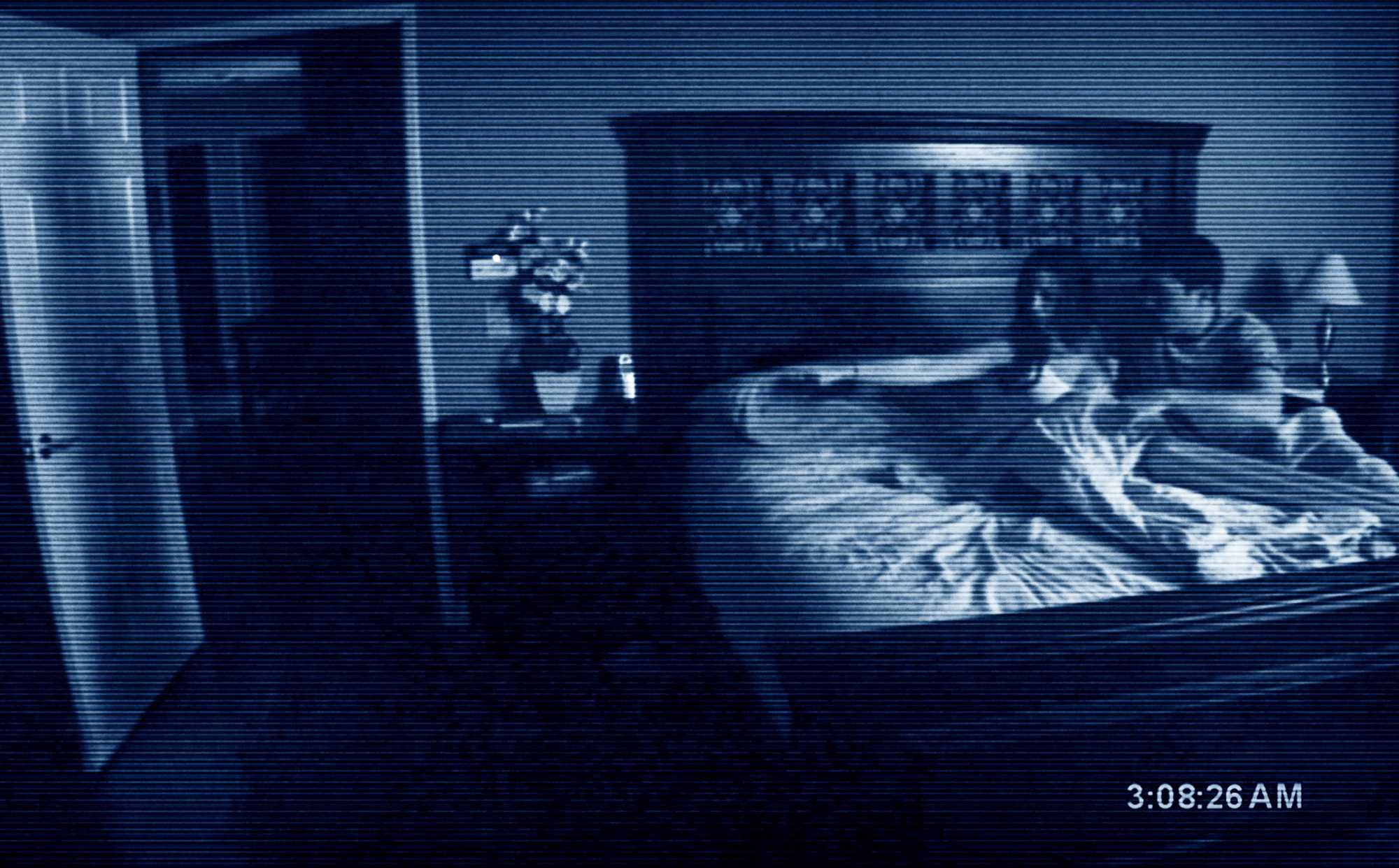 Katie and Micah from Paranormal Activity pointing at a shadow on their bedroom door