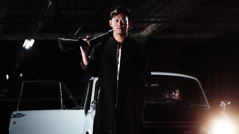 'One Arm' Wang arrives on the scene while holding a shotgun.