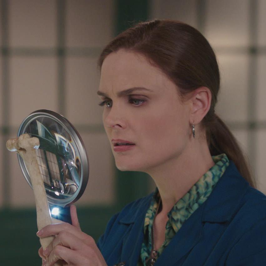 The main character analyzing a bone in a magnifying glass.