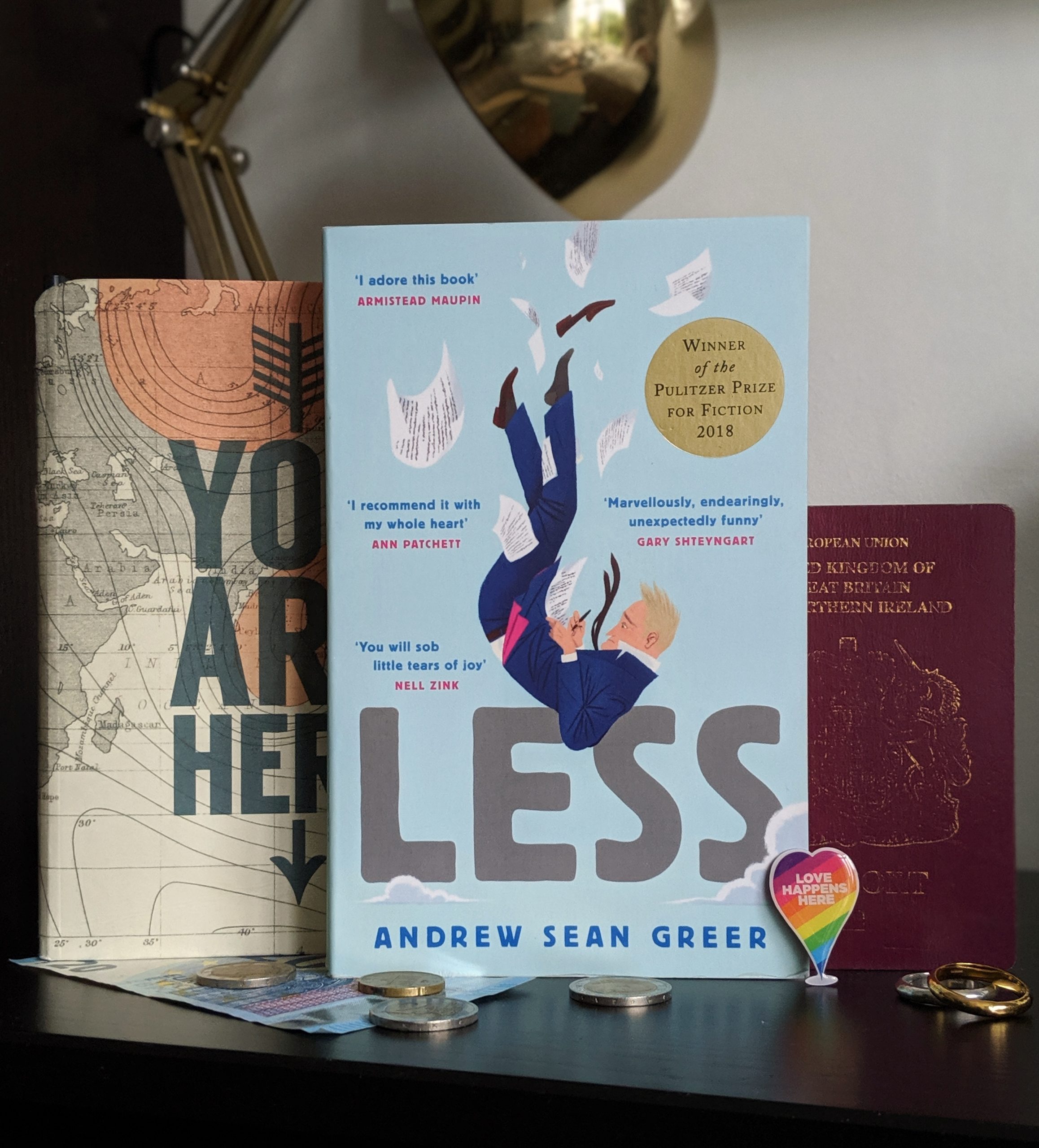 Quarter-Life Crisis Books: Andrew Sean Greer's book, Less, sitting in front of a map and passport.