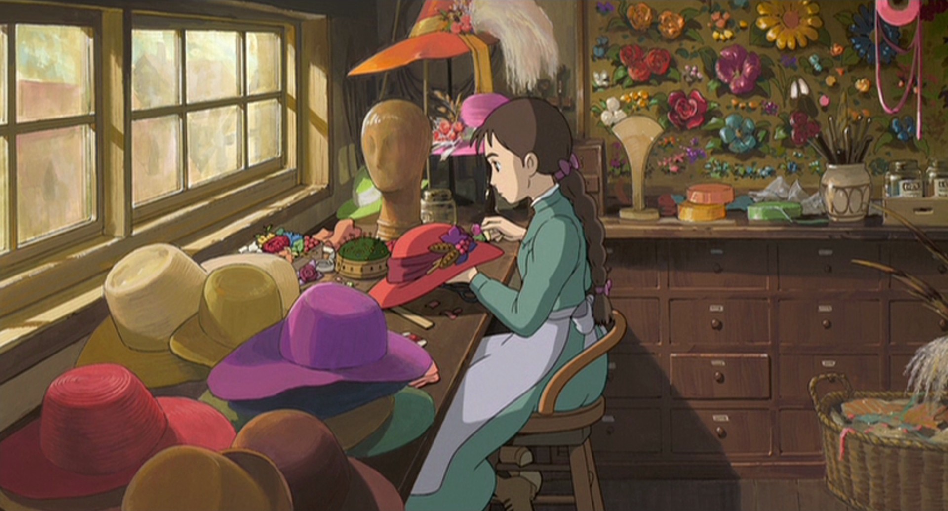 Movies To Inspire: A young Sophie sits sewing an elaborate hat.
