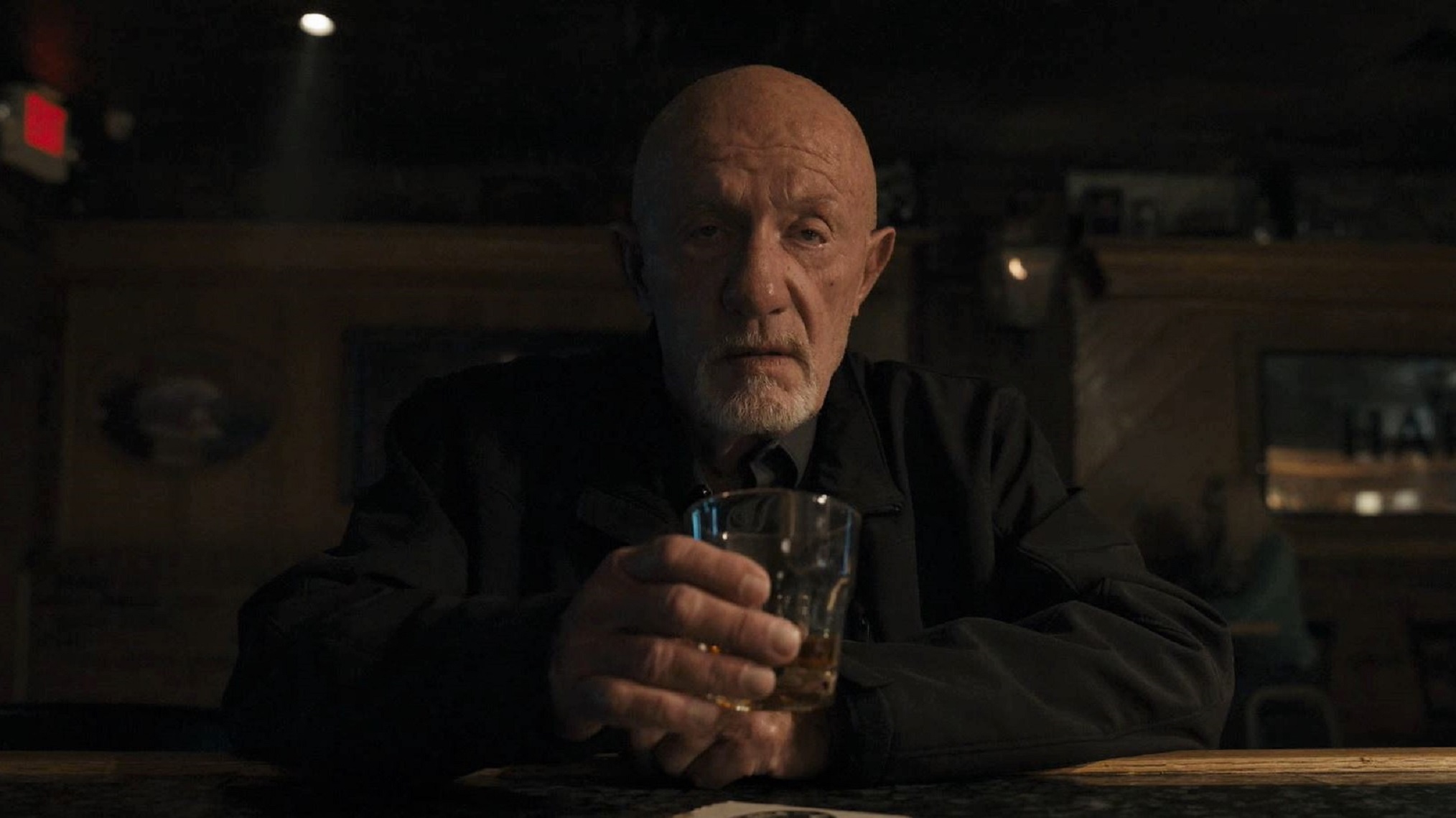 Mike sits at a bar with a drink in his hand in Season 5 of Better Call Saul.