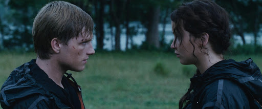 Peeta looks at Katniss during their last moments in the arena.
