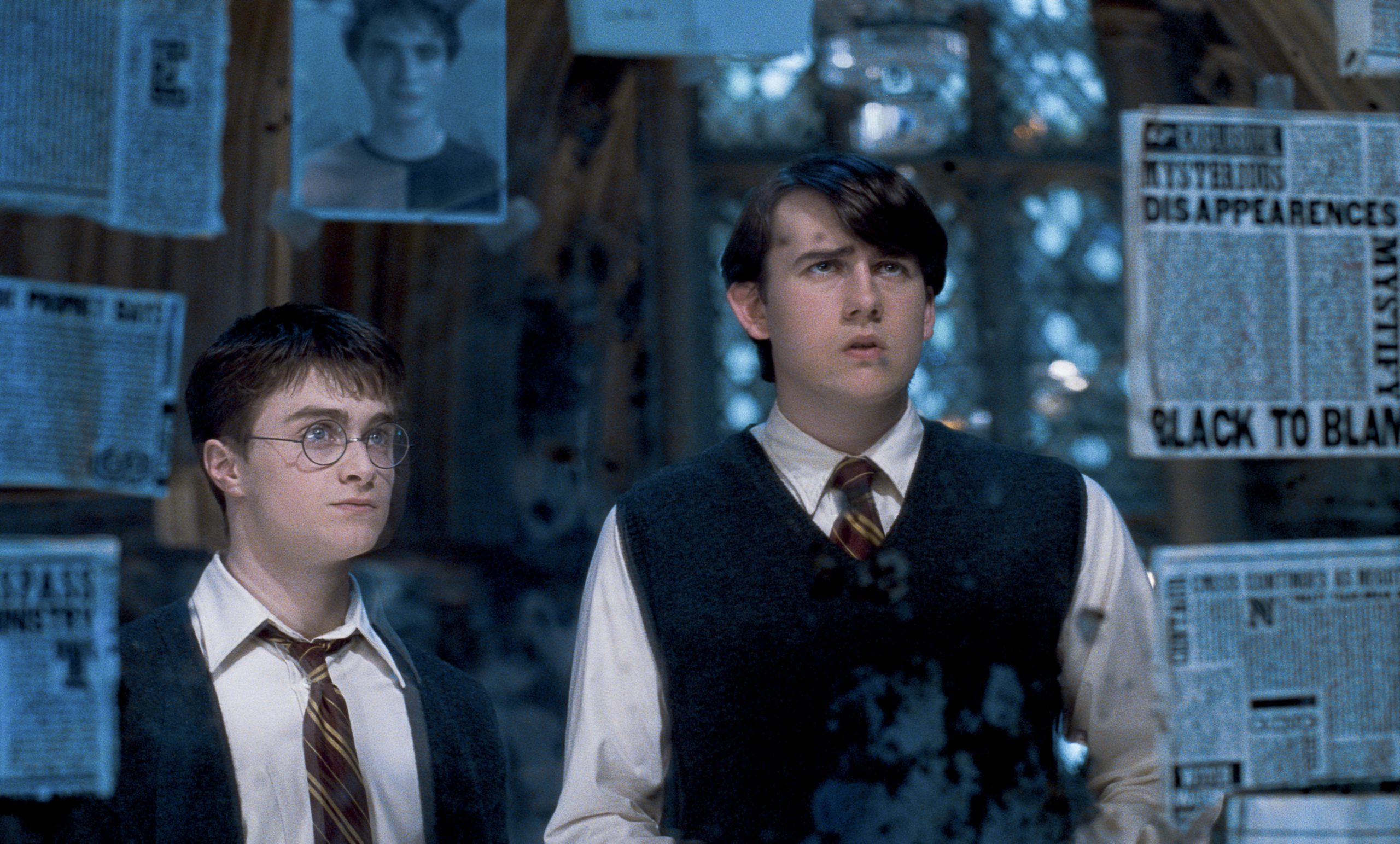 Harry Potter and the Order of the Phoenix, Harry and Neville staring at articles and photos taped to a mirror.