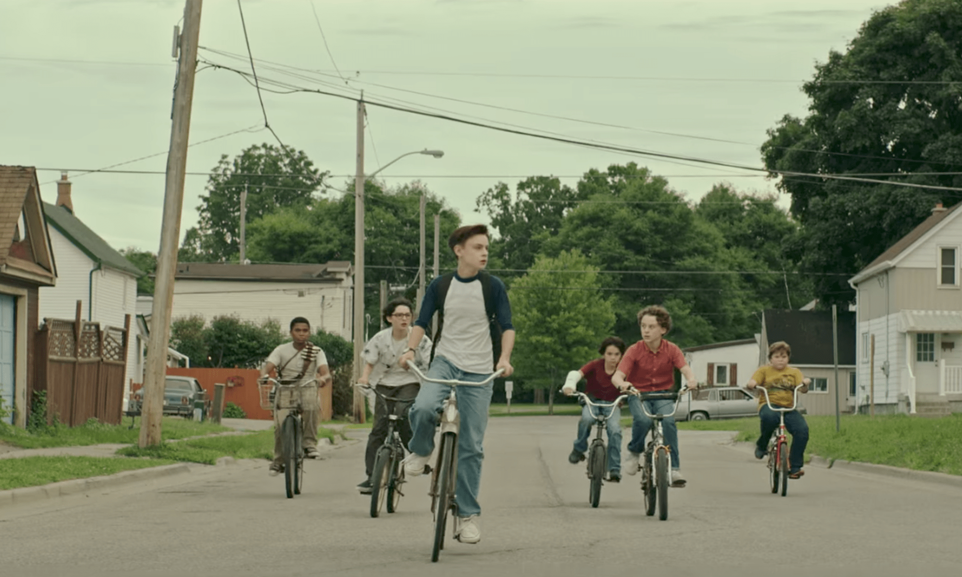 (from left to right) Richie, Stanley, Bill, and Eddie from the 2017 adaption of Stephen King's IT riding their bikes down the street.