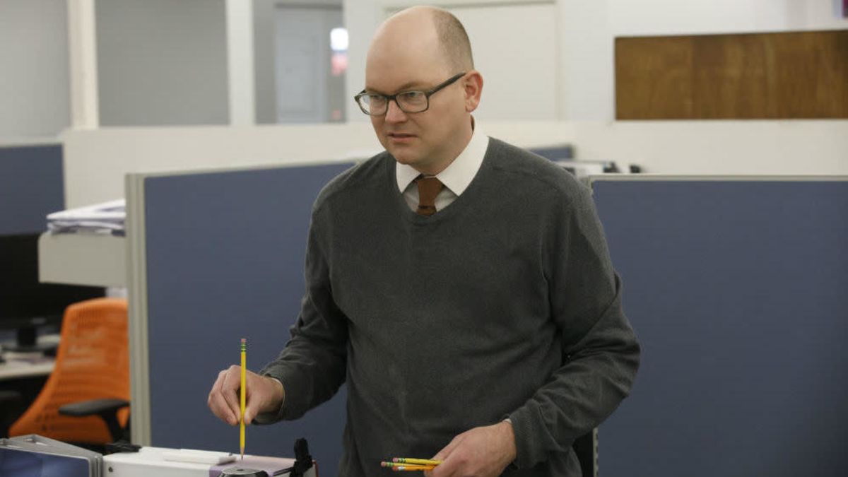 Colin Robinson in the office, sharpening multiple pencils.