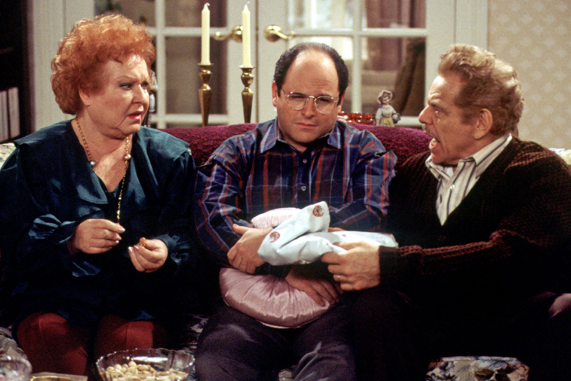 George and his parents sitting in their living room, George, seemingly unhappy as usual in Seinfeld.