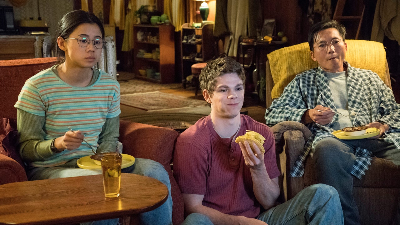 Stars of The Half of It, Leah Lewis, Daniel Diemer, and Collin Chu sit in a living room eating taco sausages