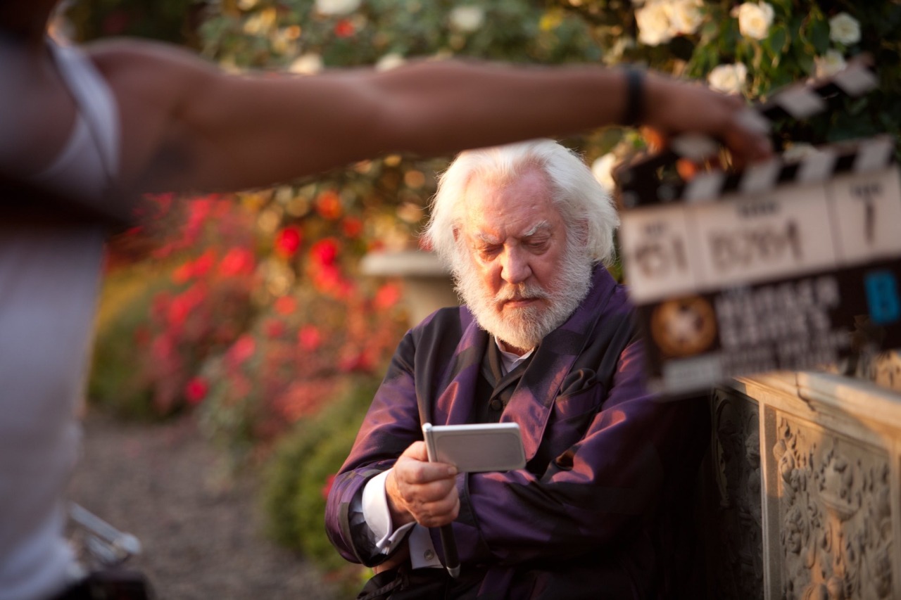 Donald Sutherland on set of The Hunger Games reads a card.