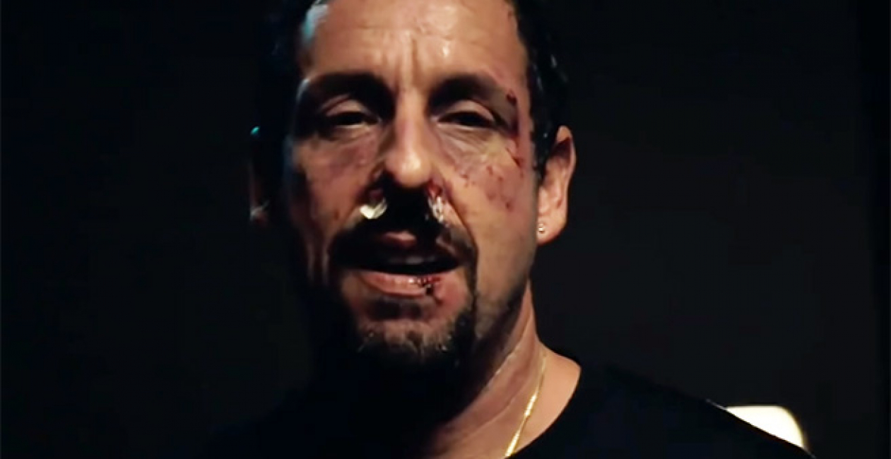 A bloody Adam Sandler looks at the camera in Uncut Gems.