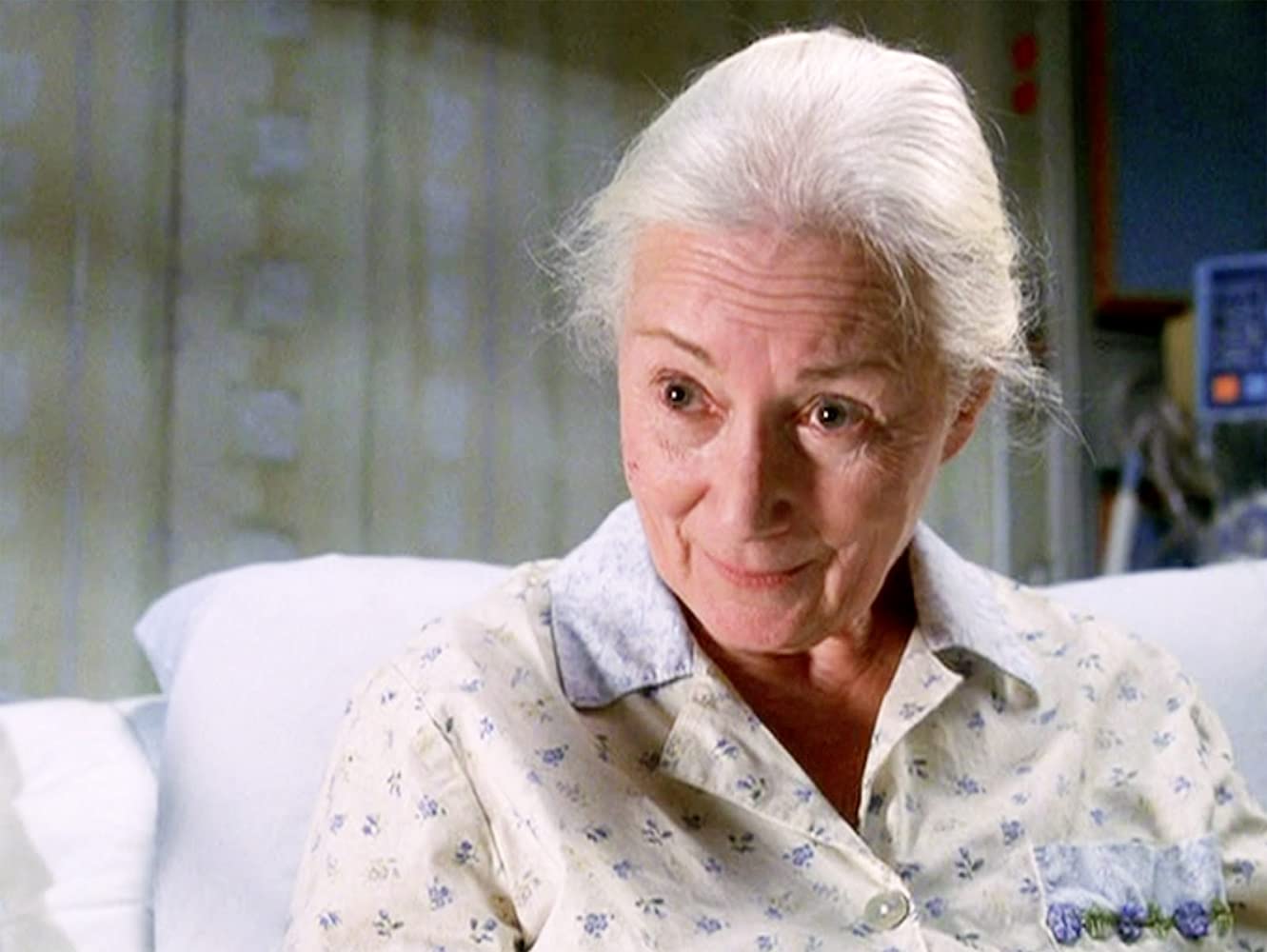 Aunt May sits in a hospital bed, talking.