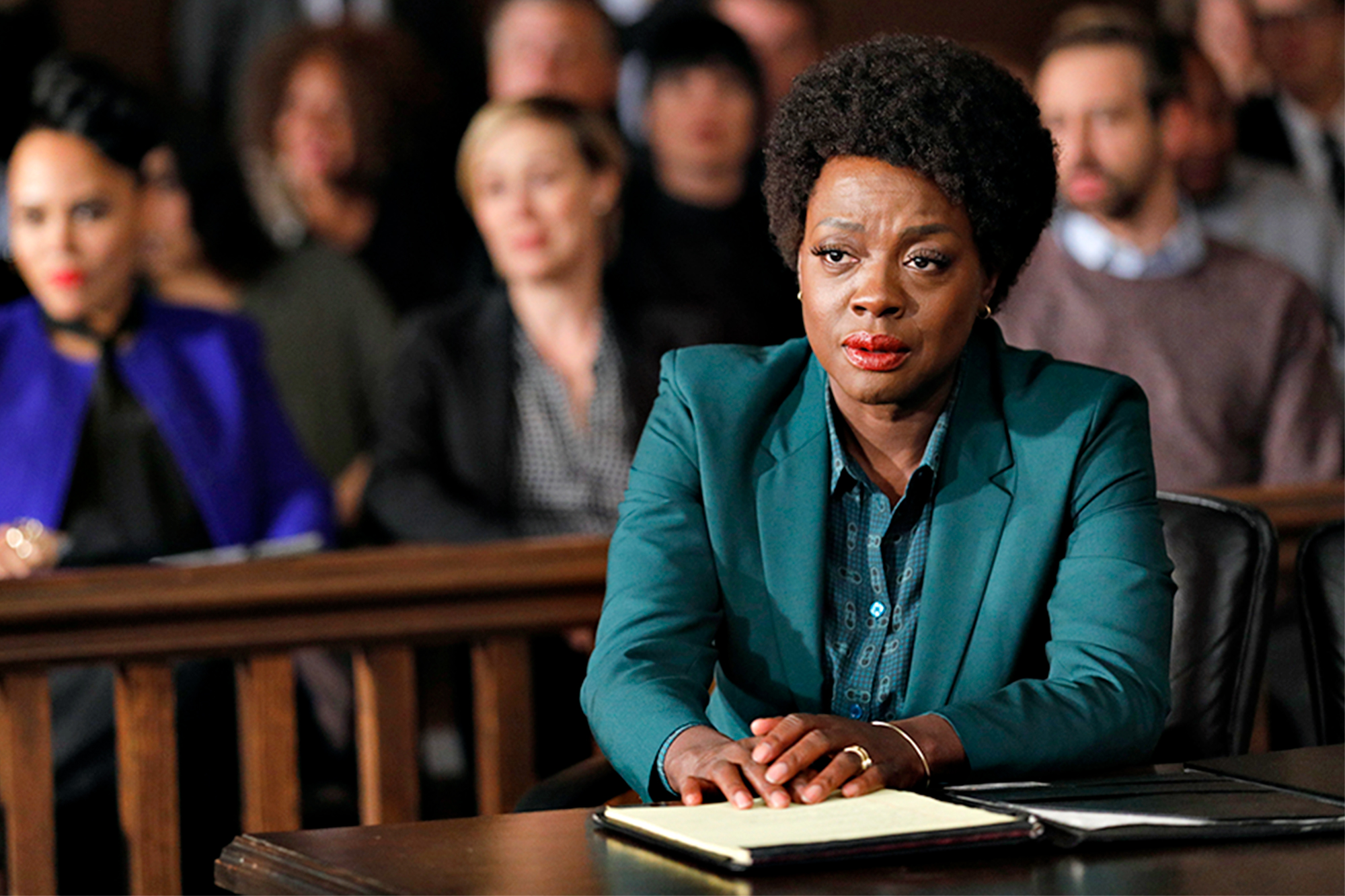 Annalise Keating in front of the courtoom in teal suit facing the death penalty.