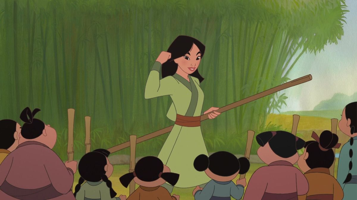 Mulan, in Disney's Mulan II, stands with a staff in front of a group of children.