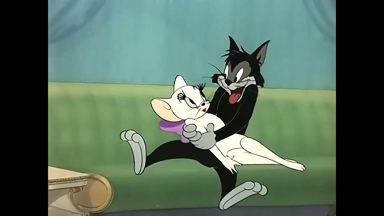 Scene from Tom and Jerry. A male black cat holding a white cat on a green couch