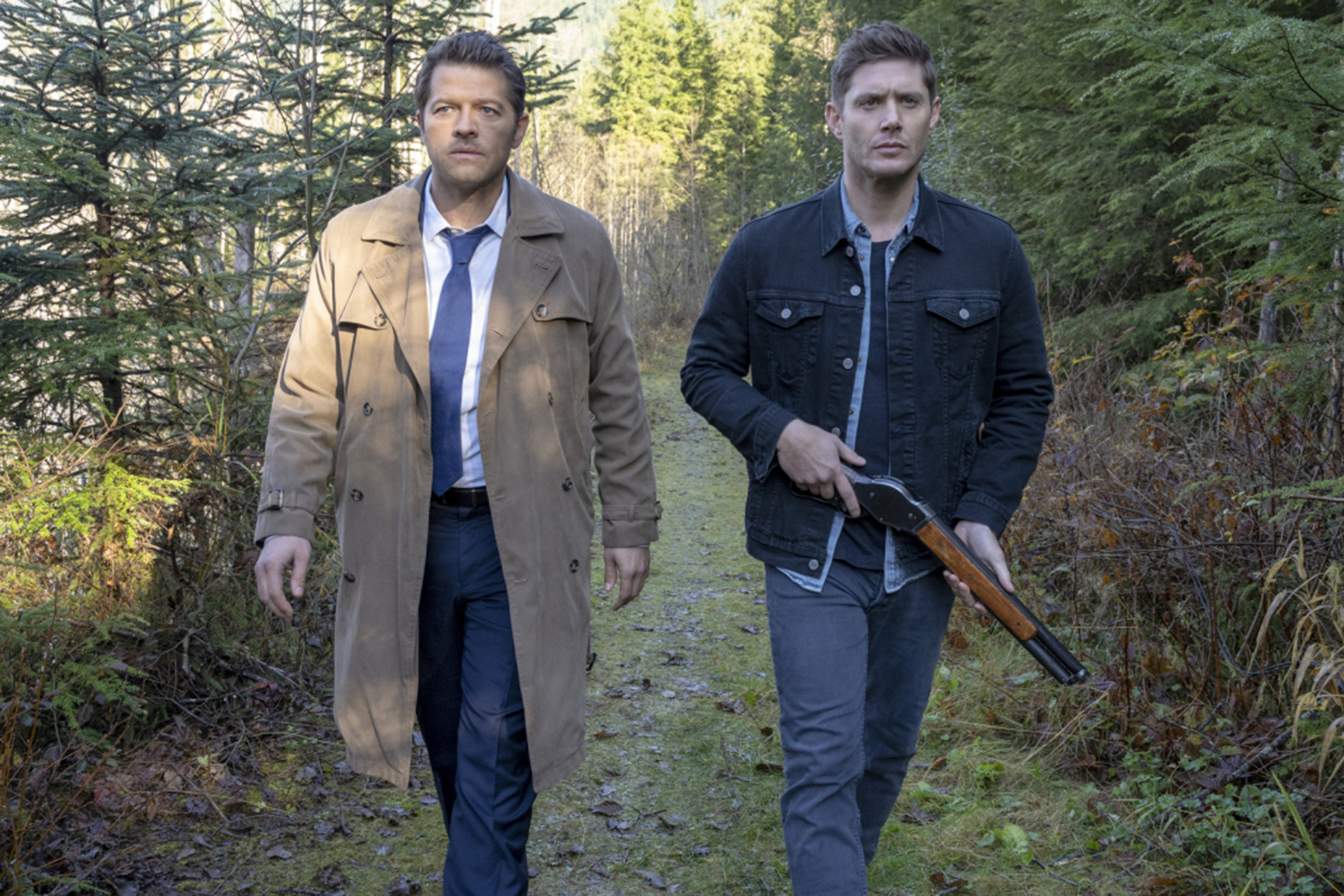 Castiel and Dean walking in the woods.