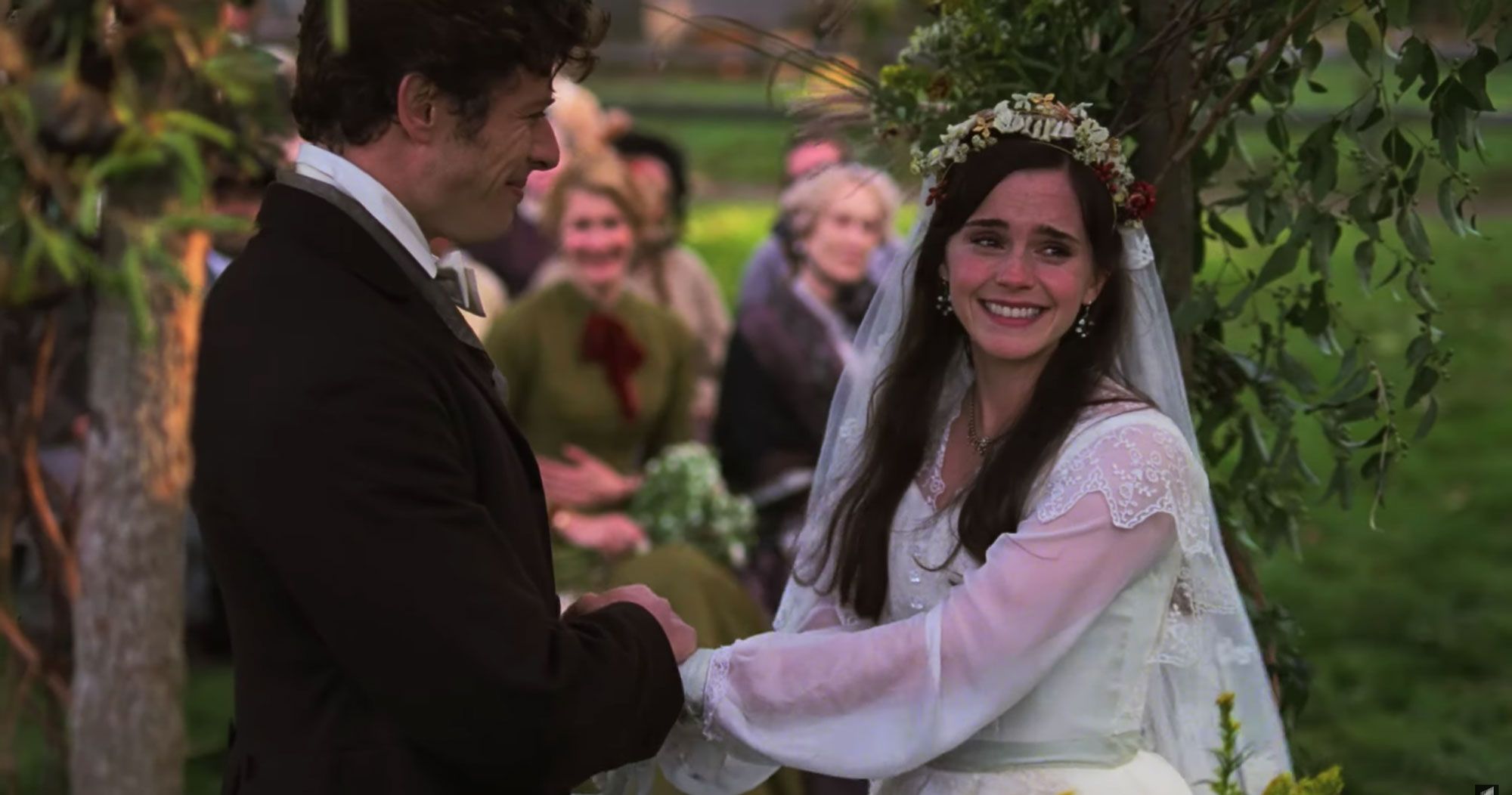 Meg stands in her wedding dress, holding hands with her soon-to-be husband.