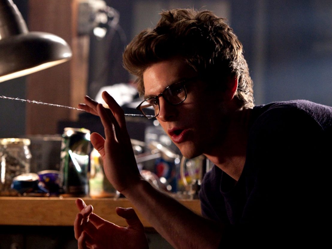 Peter Parker examines a web-shooter thread he has created.