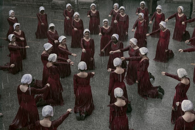 The handmaids get punished for not turning on their fellow handmaid Janine in season 1 by holding rocks till they can't feel their arms.  