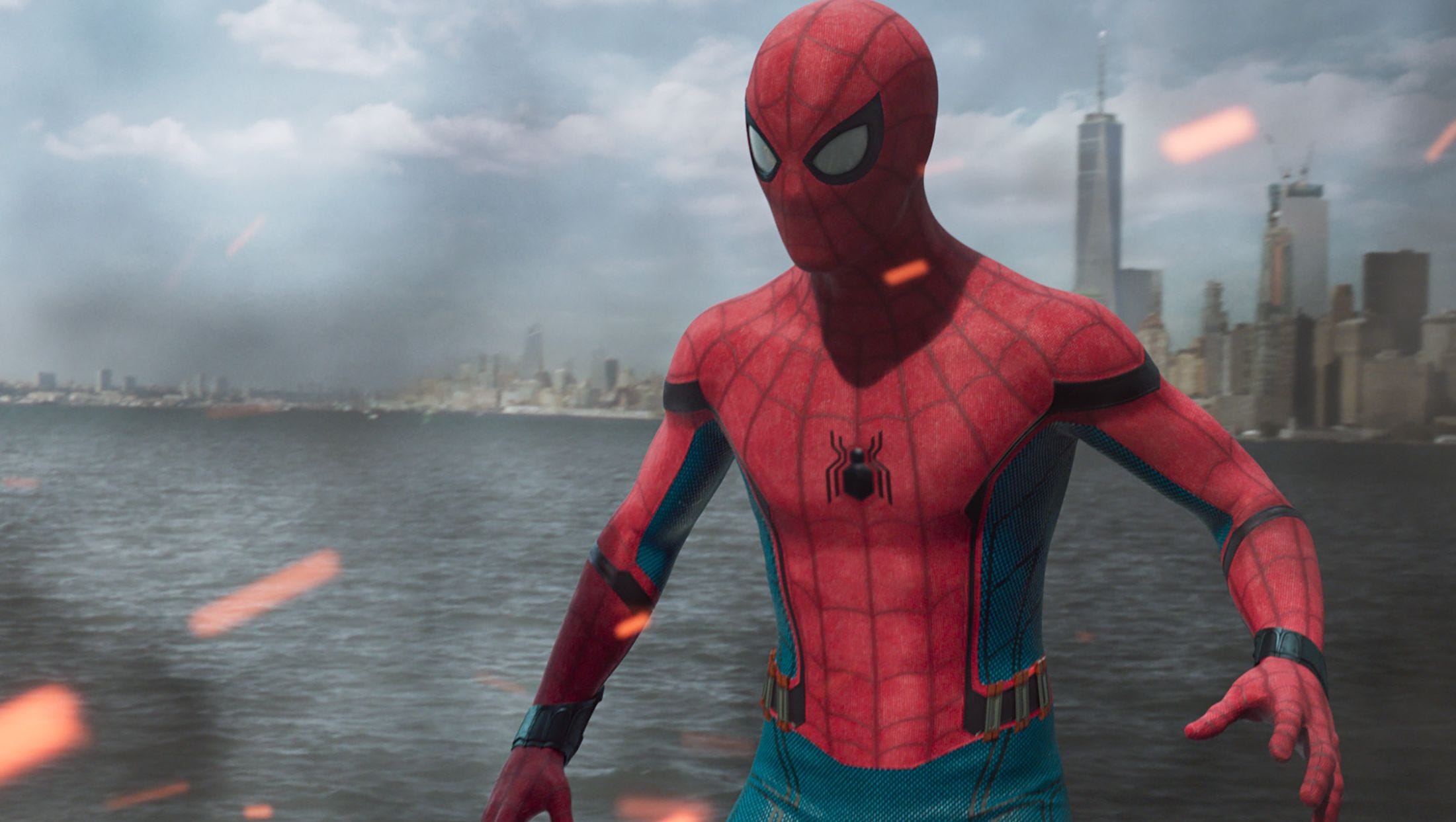 Spider-Man stands on a burning boat in the waters in front of New York City.