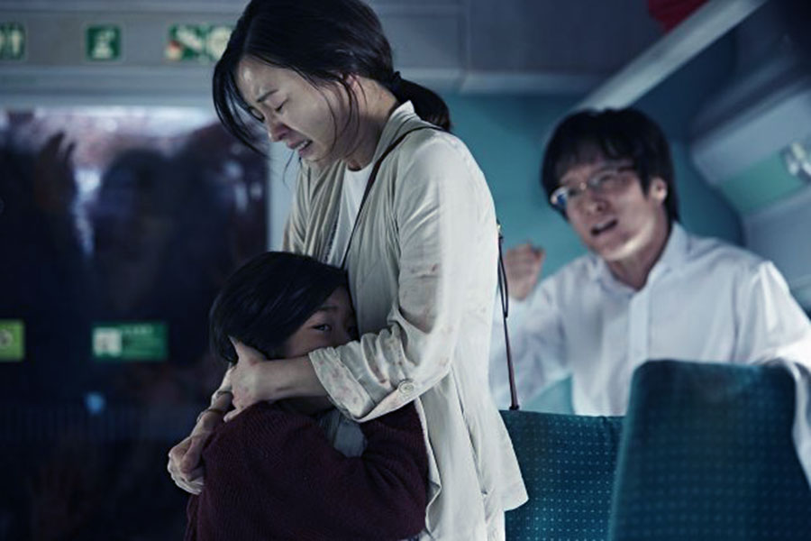 Sung-gyeong holding Su-an as passengers yell at them to leave the car. 