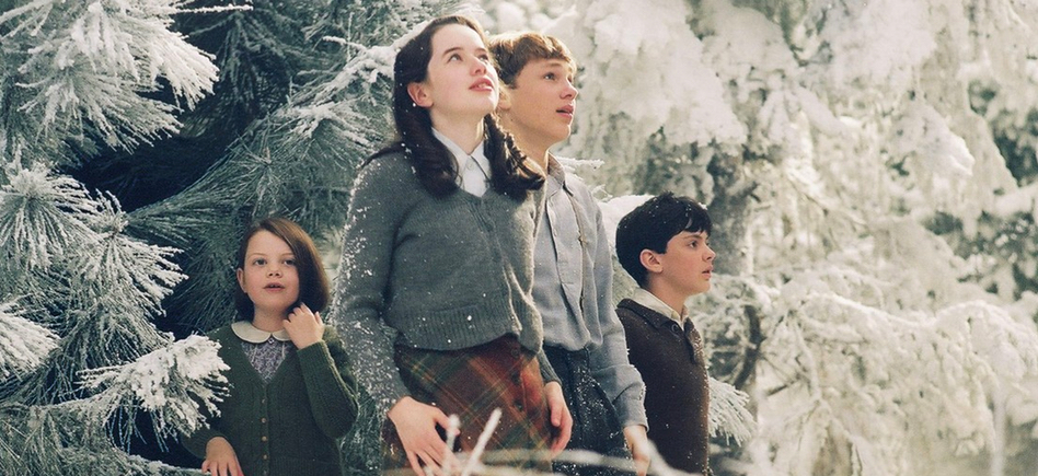 Four children stand against a snowy forest backdrop while staring off-screen in wonder.