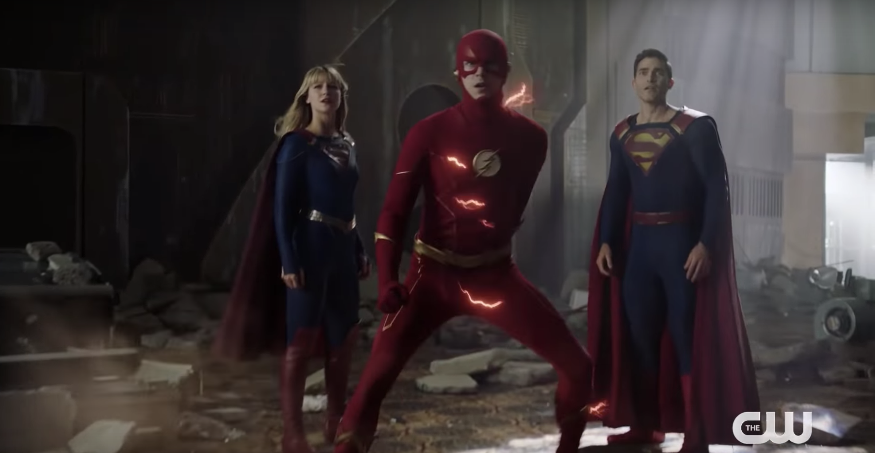 Flash, Supergirl, and Superman from parallel universes stand together, ready to fight danger across their entire multiverse.