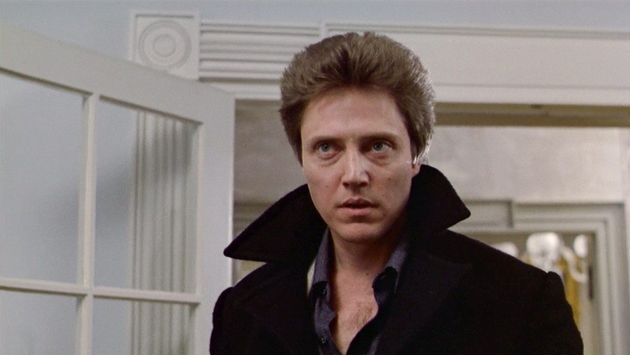 Johnny Smith stares at something offscreen, dressed in a black jacket.