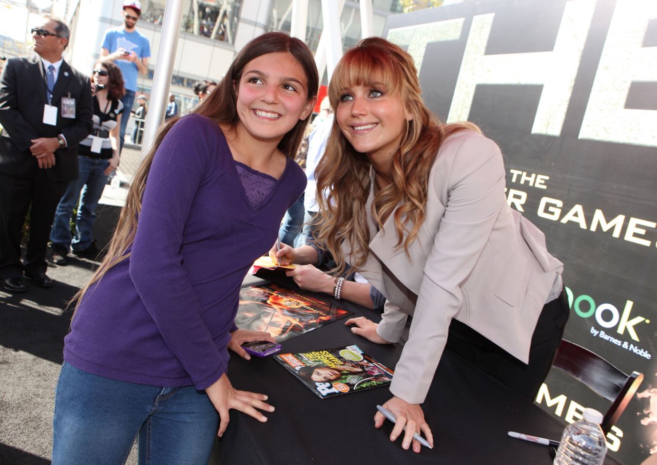 Actress Jennifer Lawrence taking a picture with a Hunger Games fan. 