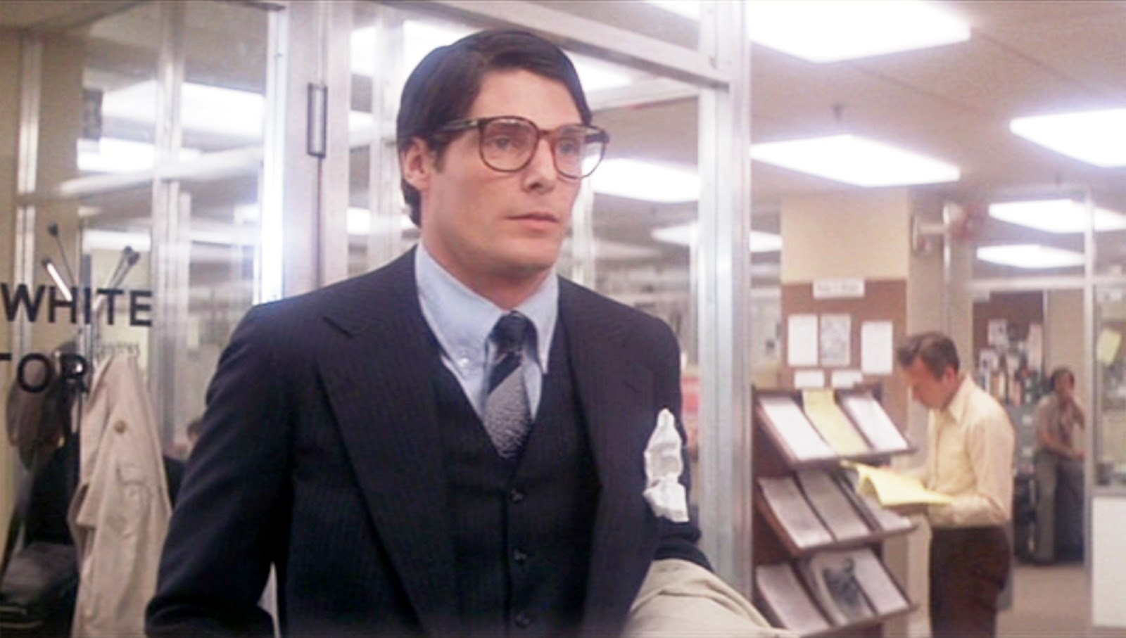 Clark Kent is standing by his Daily Planet desk in Superman (1978). 