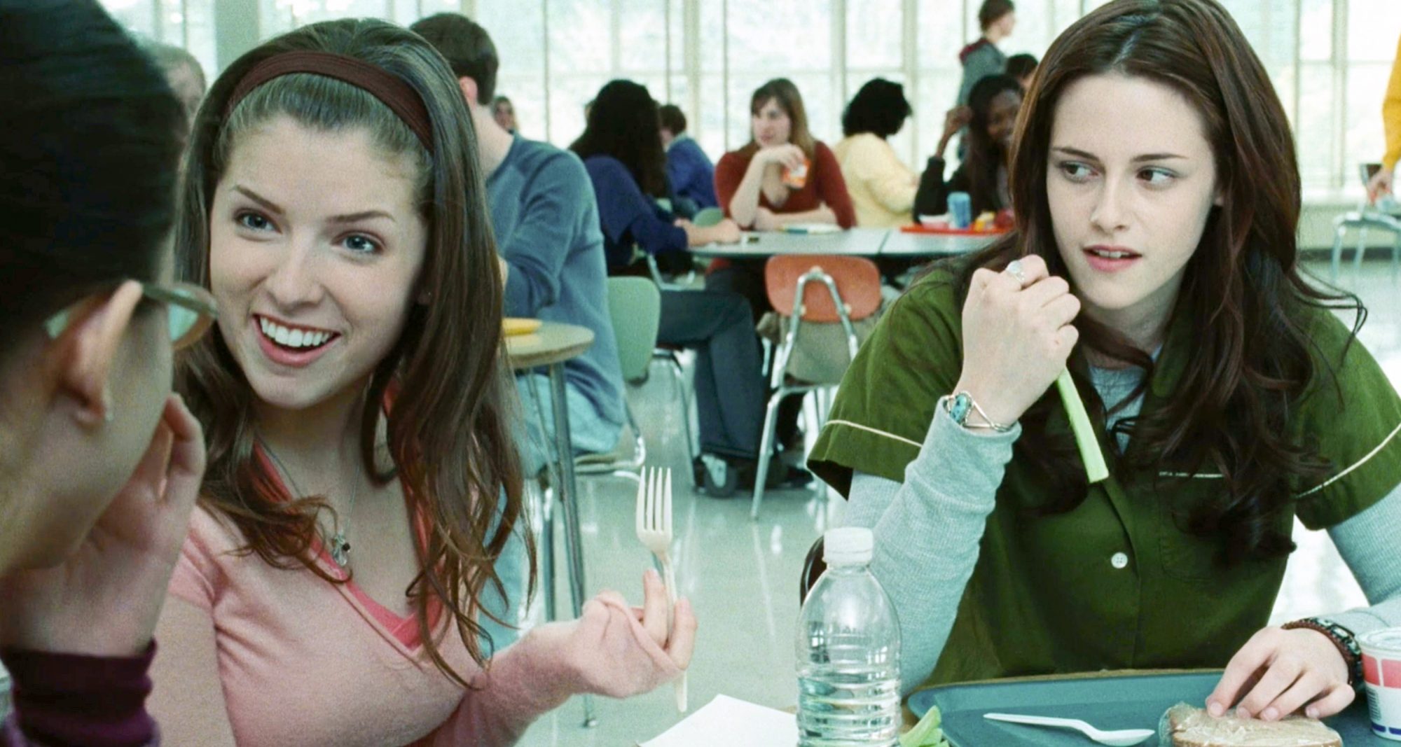Bella Swan sitting in the cafeteria looking at her friend, Jessica Stanley. 