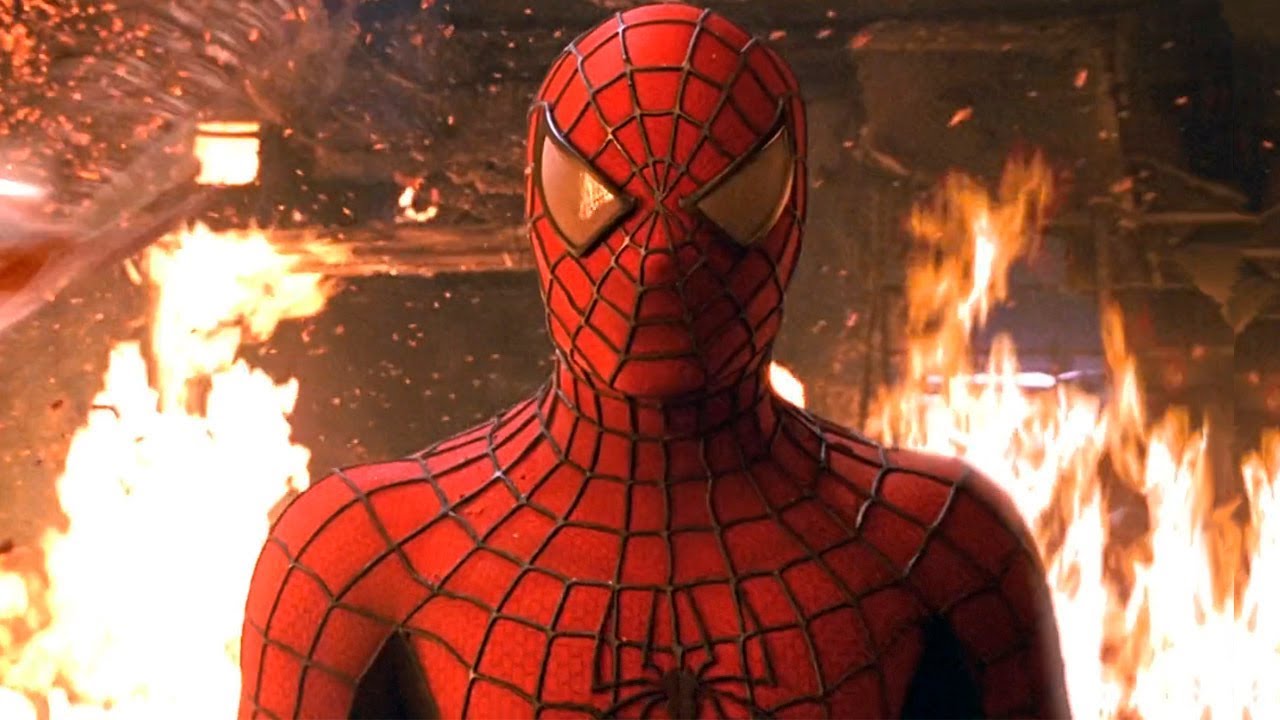 Spider-Man stands in front of a burning fire.