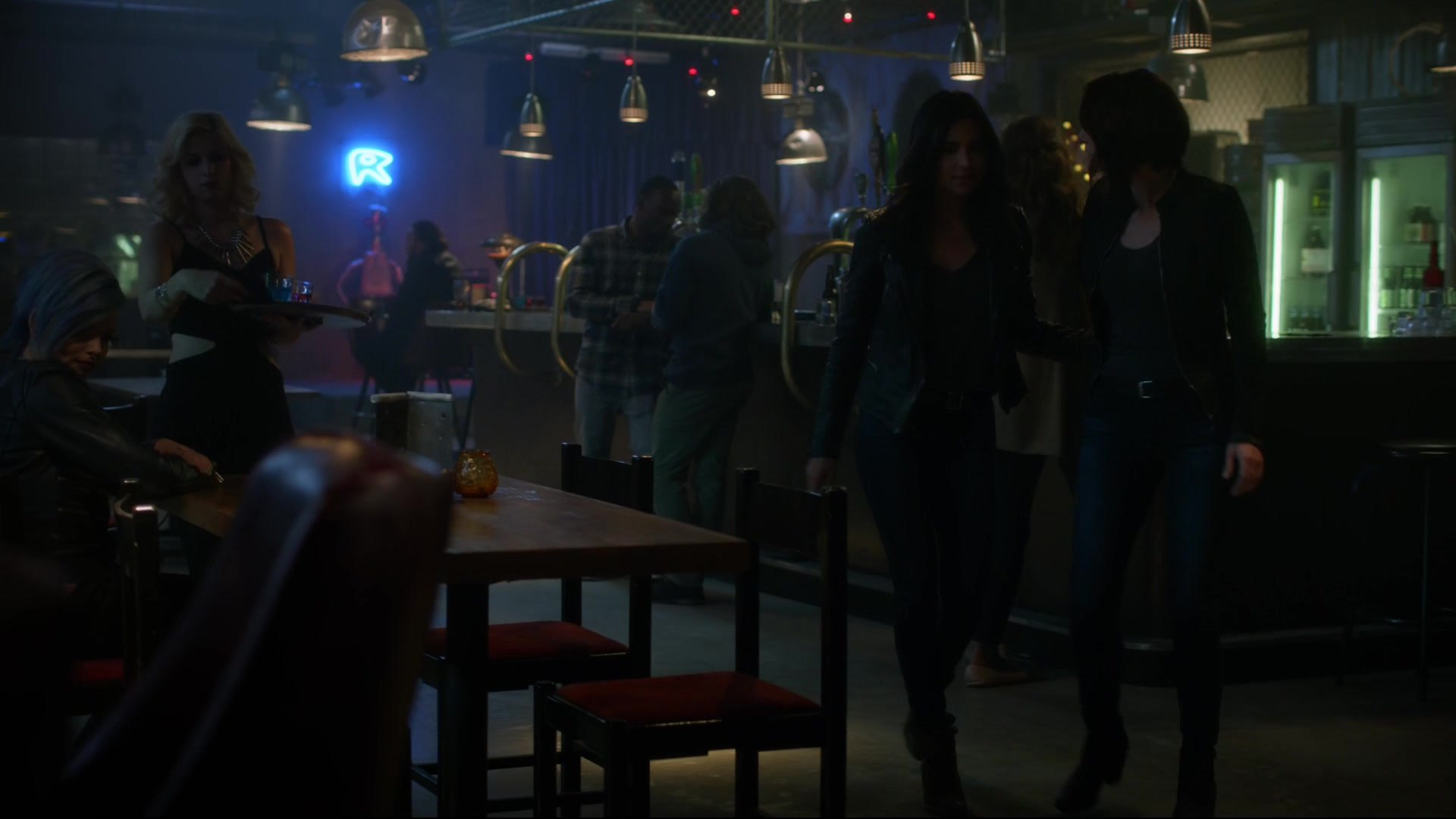 Supergirl's sister and her sister's girlfriend seem to be leaving a bar for aliens. 
