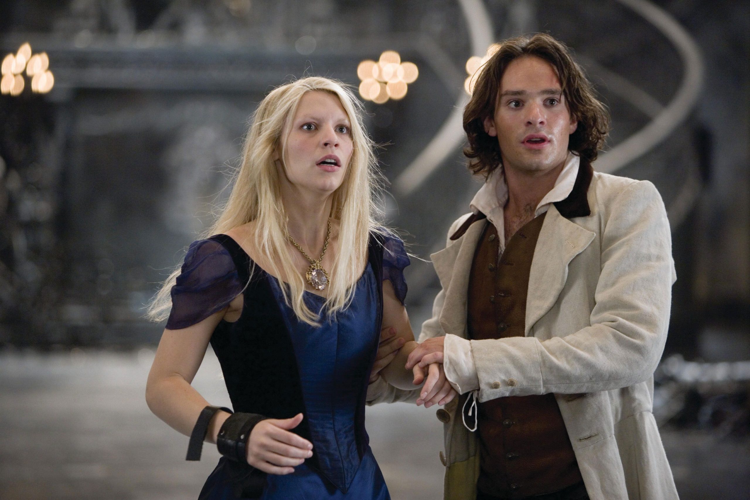 Tristan (played by Charlie Cox) and Yvaine (played by Claire Danes) from the movie Stardust hold each other as they look at something with fear in their eyes.