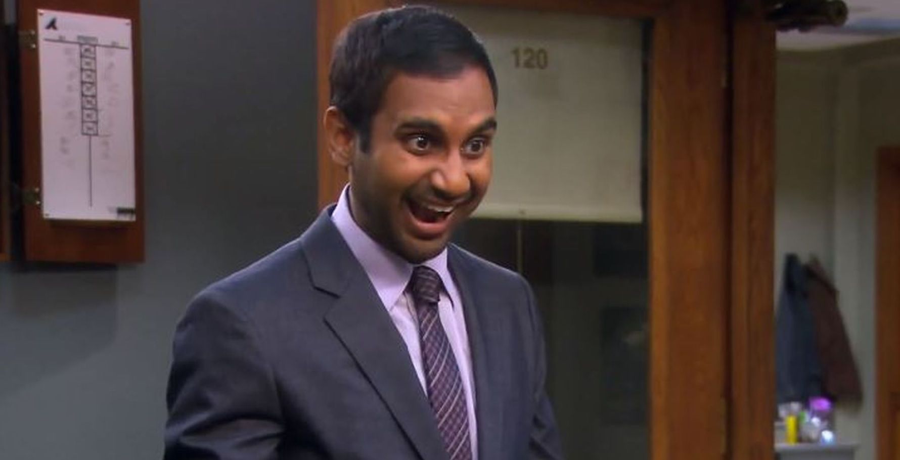 Tom Haverford grins at a colleague. 