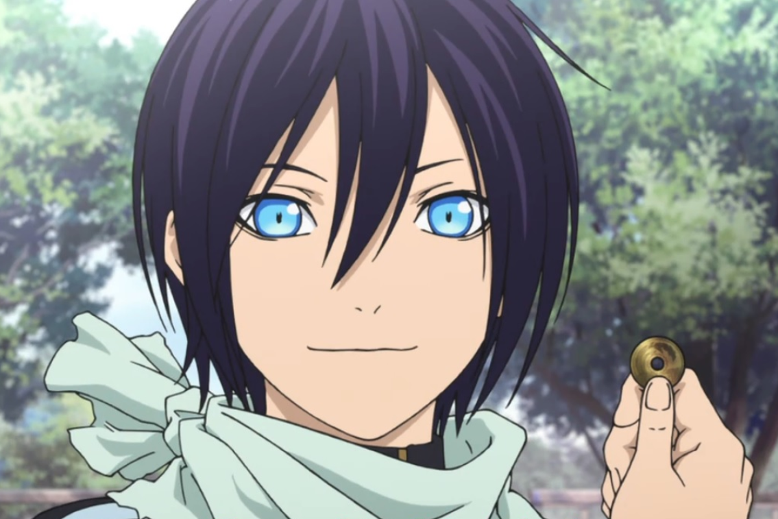 Yato, the main character of Noragami, stands in front of trees, smiling and holding up a five yen piece. 