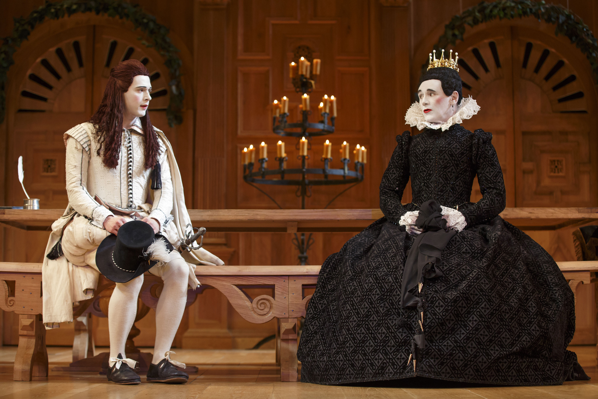 Olivia and Viola sit next to each other on a bench in an Elizabeth Era production of Twelfth Night. 