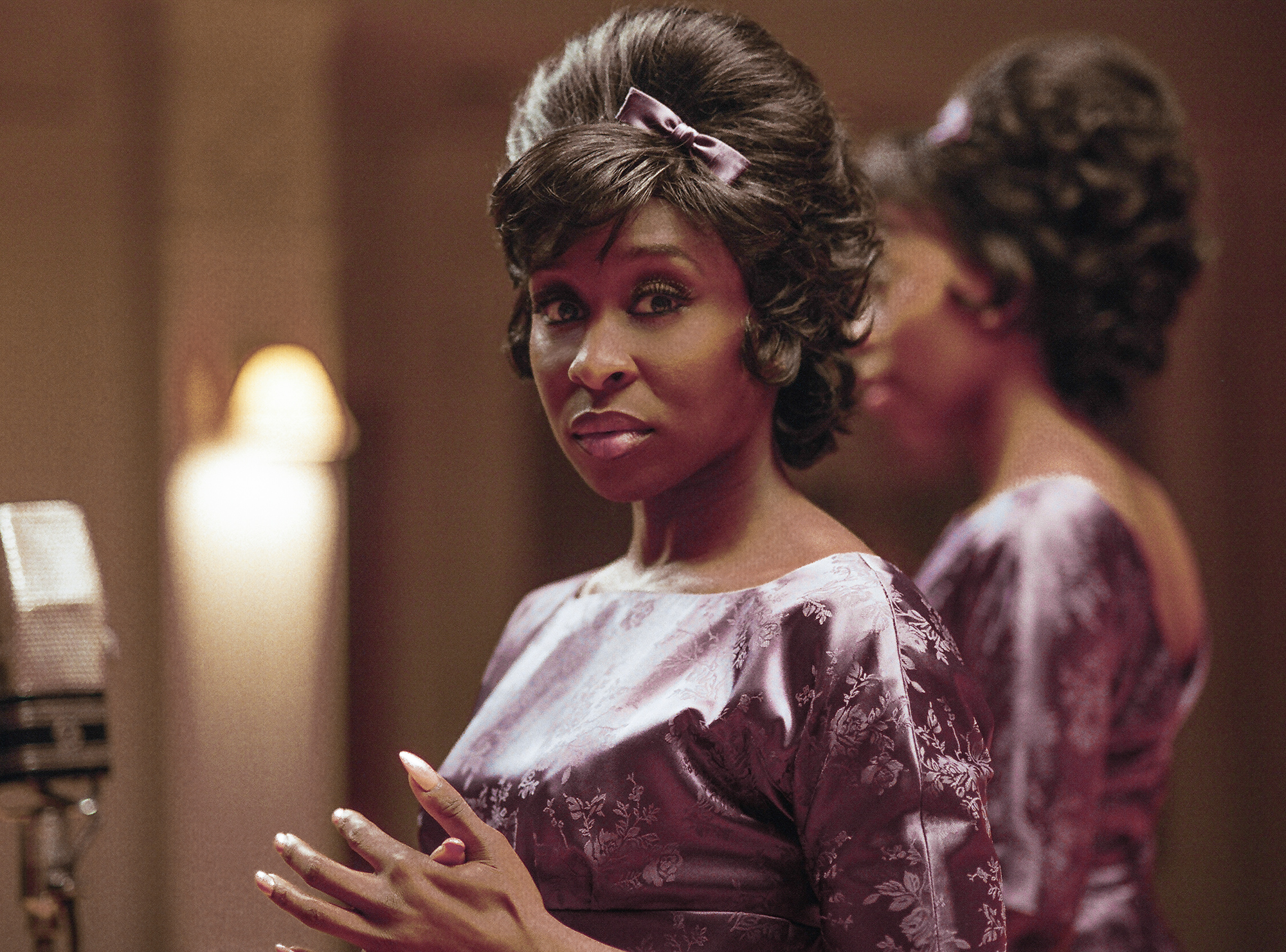 Darlene Sweet stands looking at the camera in a floral, purple dress. 