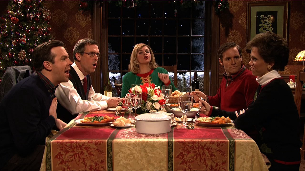 Judith (Kristen Wiig) sits with her family at the tense dinner table during another "Dysfunctional Family Dinner." 