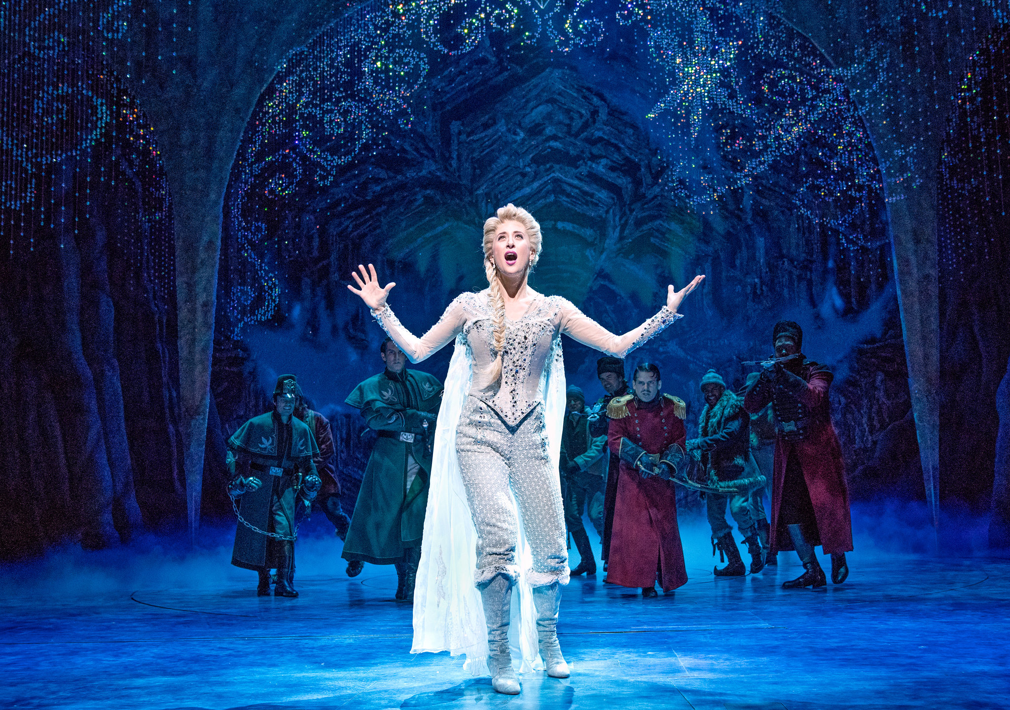 Caissie Levy, as Elsa, stands in her ice castle in the musical adaptation of Frozen.