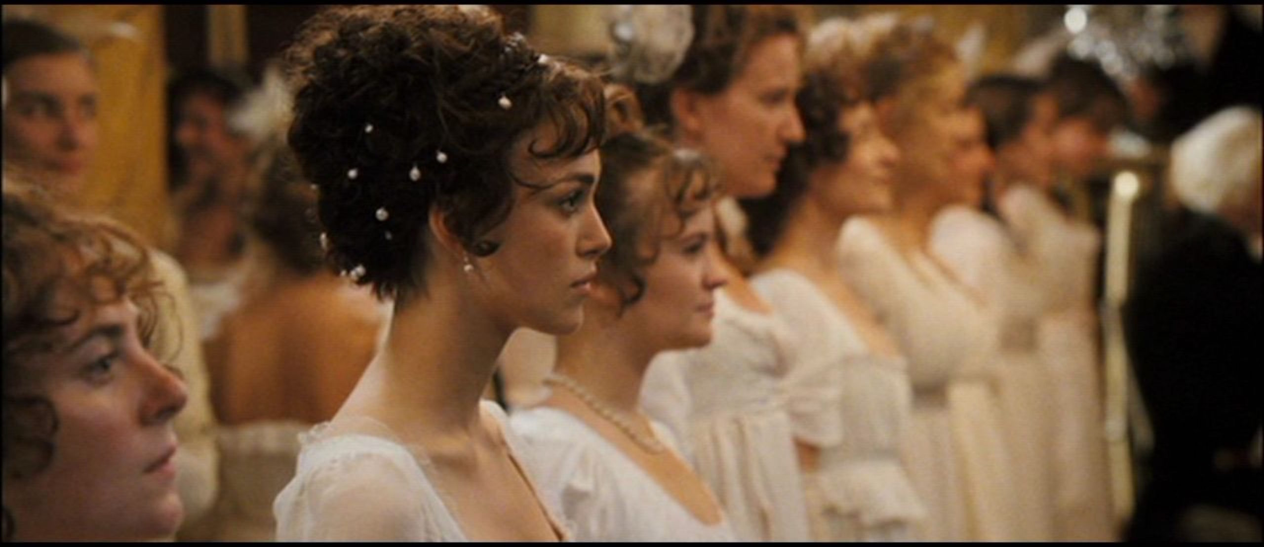 Elizabeth standing among a row of ladies during the dance with Mr. Darcy at the Netherfield Ball. 