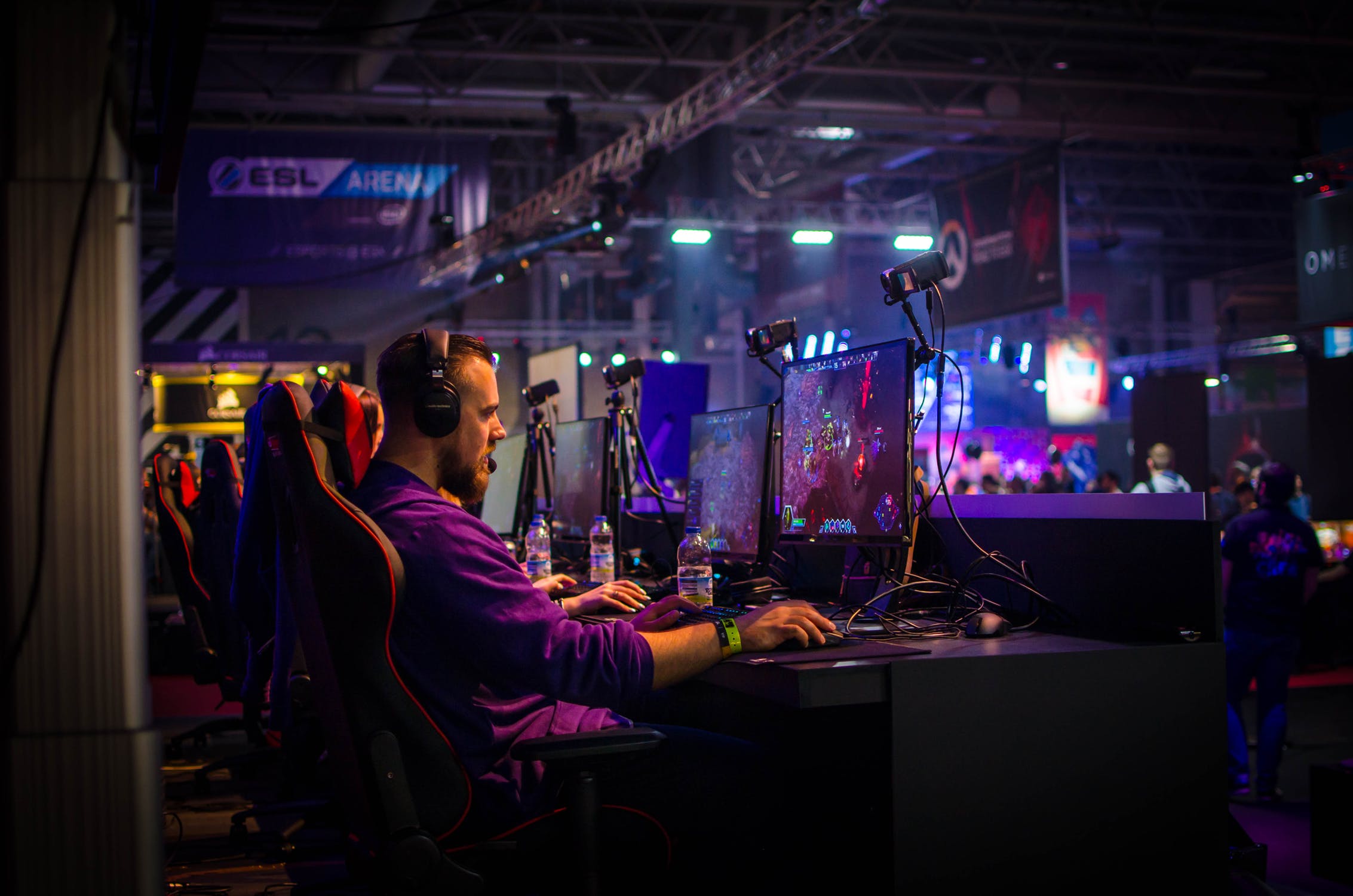 A man is playing a video game on stage at the ESL Arena.