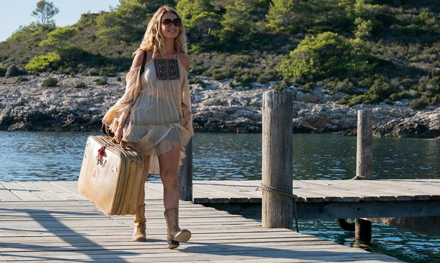 In Mamma Mia 2, Donna arives on the island of Kalokairi in a dress, holding a suitcase.