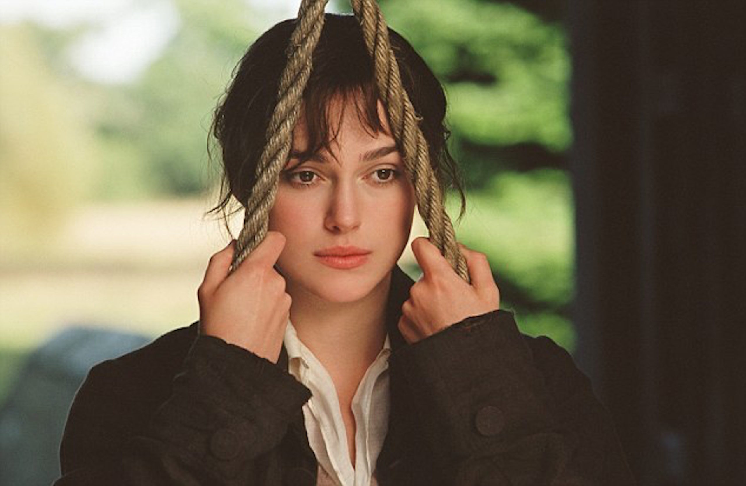 Keira Knightley as Elizabeth Bennet holding onto the ropes of the swing she's sitting on. She looks like she's in a trance.