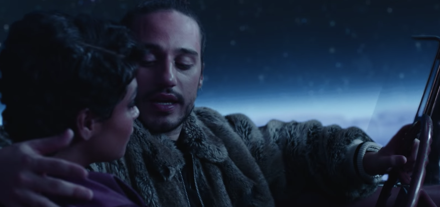 Russ has his arm around a woman while driving in the music video for "Missin You Crazy" (2018).