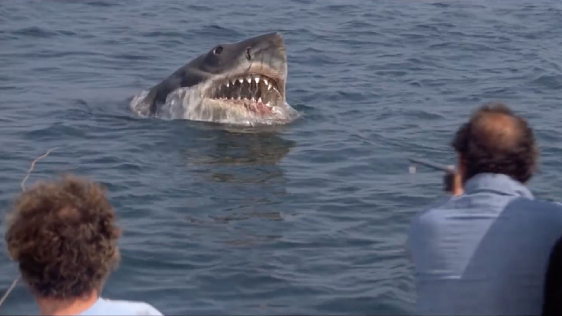 Bruce, the Jaws shark, lunges out of the water while Quint takes aim.