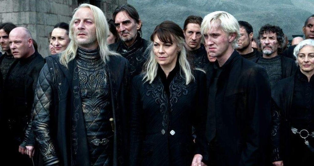 Lucius, Narcissa, and Draco Malfoy standing at the Battle of Hogwarts.