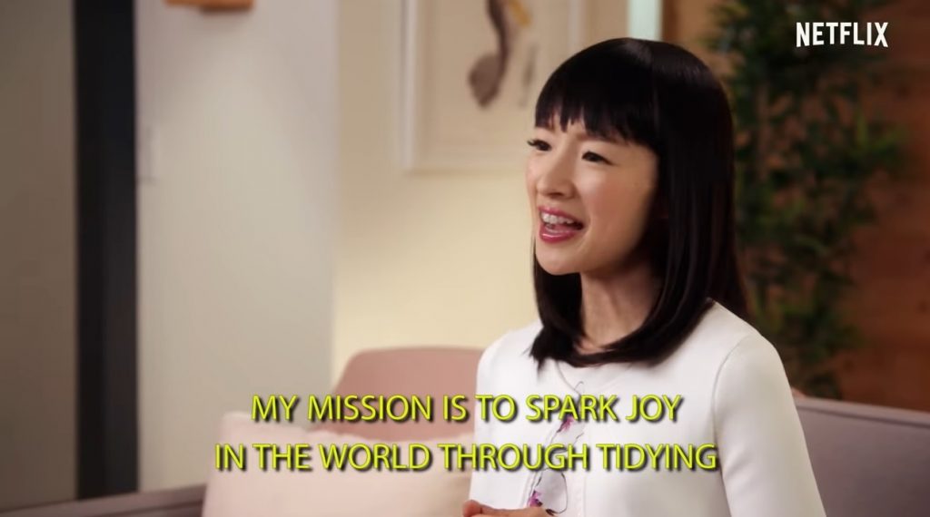 Marie Kondo says the quote, "My mission is to spark joy in the world through tidying," in yellow letters.