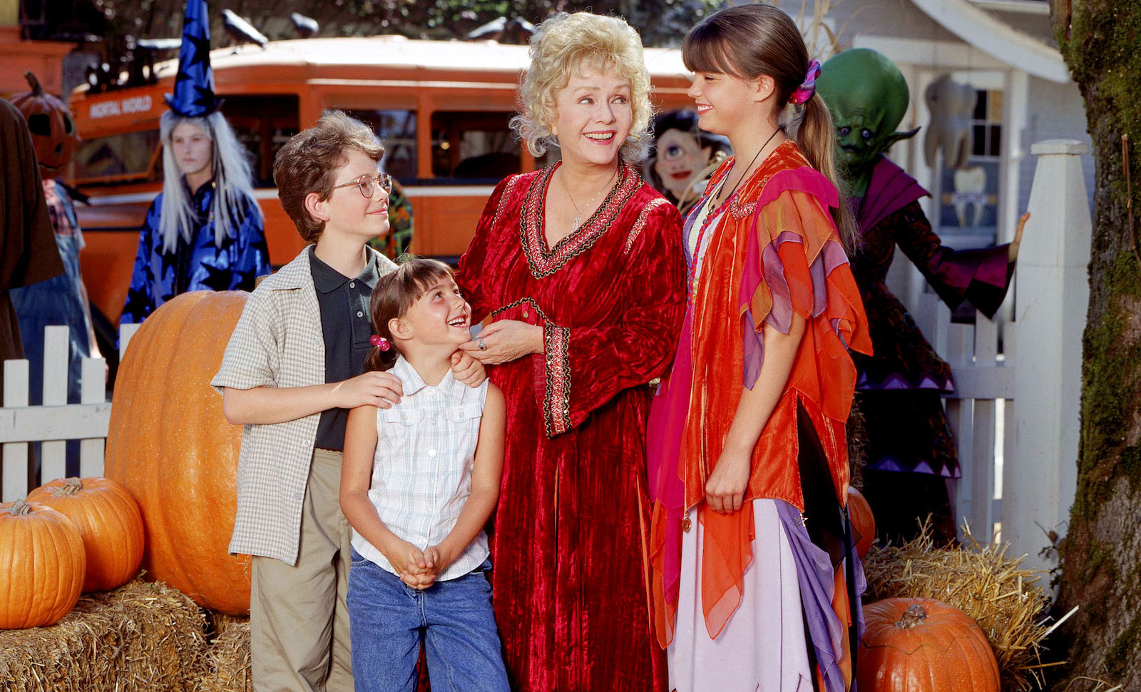 Four characters from the movie Halloweentown look at each other smiling.